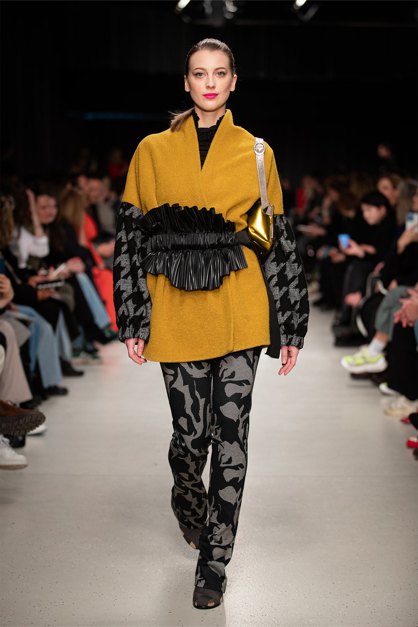 model walking on the runway of bcefw wearing mustard yellow overlapped coat